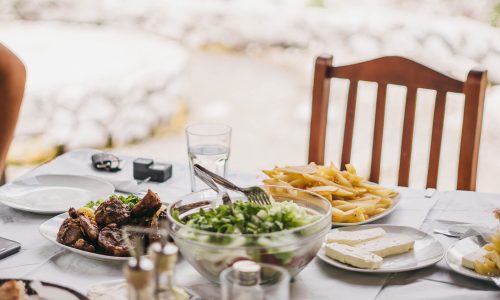 A table showing a traditional Albanian meal with meat, potatoes, salad and cheese