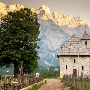 A stunning view of the chuch in Theth Northern Albania with the majestic Albanian Alps mountains rising in the background