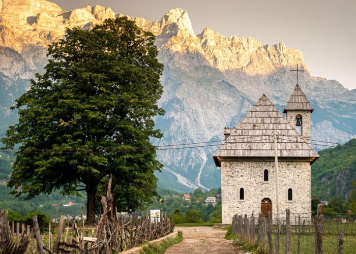 A stunning view of the chuch in Theth Northern Albania with the majestic Albanian Alps mountains rising in the background