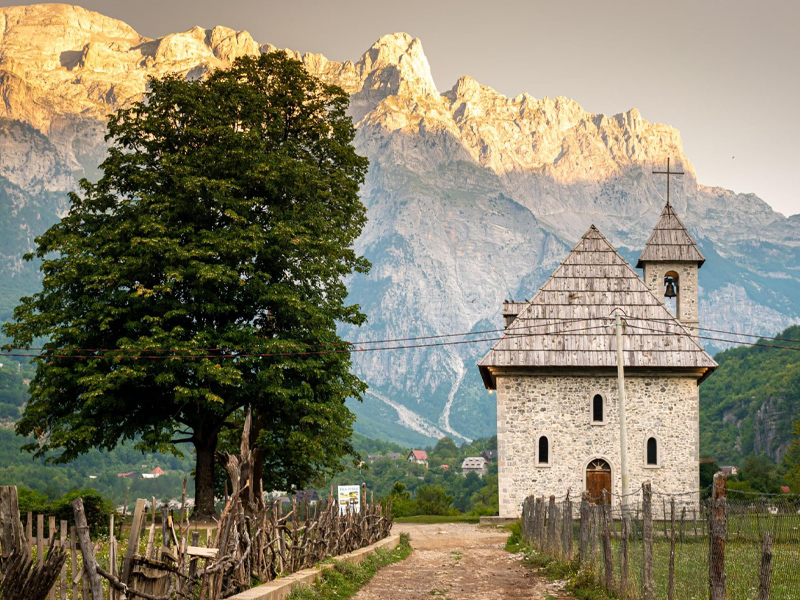 A stunning view of the chuch in Theth Northern Albania with the majestic Albanian Alps mountains rising in the background